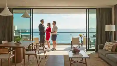Real estate agent showing a bright coastal condominium unit with a balcony to a couple