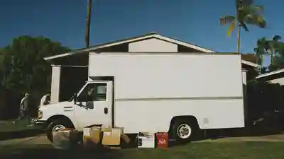 Moving truck parked in front of a Florida home with boxes on the lawn