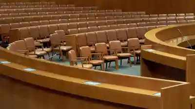 Empty municipal council chamber with a curved dais and public seating