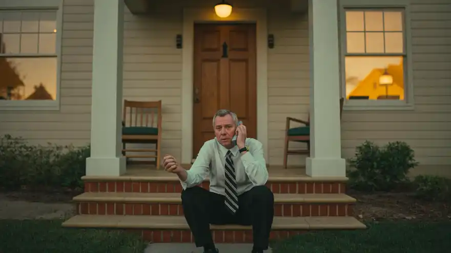 Real estate agent pausing on a porch at dusk after a long day