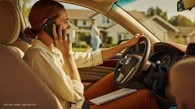 Real estate agent following up with a lead by phone from the car outside a listing